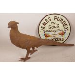 A replica cast iron sign advertising Purdy Shotguns, 9" diameter, together with a cast iron figurine