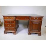 A Regency style mahogany twin pedestal partner's desk, with twelve drawers and two cupboards, the