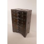 A small Indian hardwood eight drawer collector's chest with applied metal embellishments, 13½" x