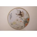 A Chinese polychrome porcelain plaque decorated with waterfowl, 11" diameter