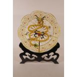 A Chinese gilt wire and enamel plaque with dragon decoration, on a hardwood stand, 10" diameter