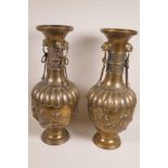 A pair of Japanese bronze two handled vases with ribbed bodies, flared necks and applied