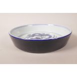 A Chinese blue and white porcelain dish with central dragon decoration, 6 character mark to base,
