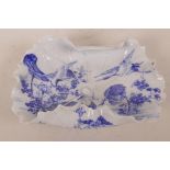 A Japanese porcelain blue and white dish moulded as a curled lotus leaf, decorated with cranes and