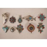 A collection of ten Tibetan white metal and hardstone pendants