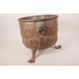 A Dutch style embossed copper log bin with lion's mask handles and three paw feet, A/F