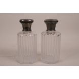 A pair of C19th cut glass bottles with fluted sides and silvered metal mounts, 6" high
