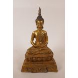 A Sino-Tibetan filled metal figure of Buddha with gilt patina, 10" high