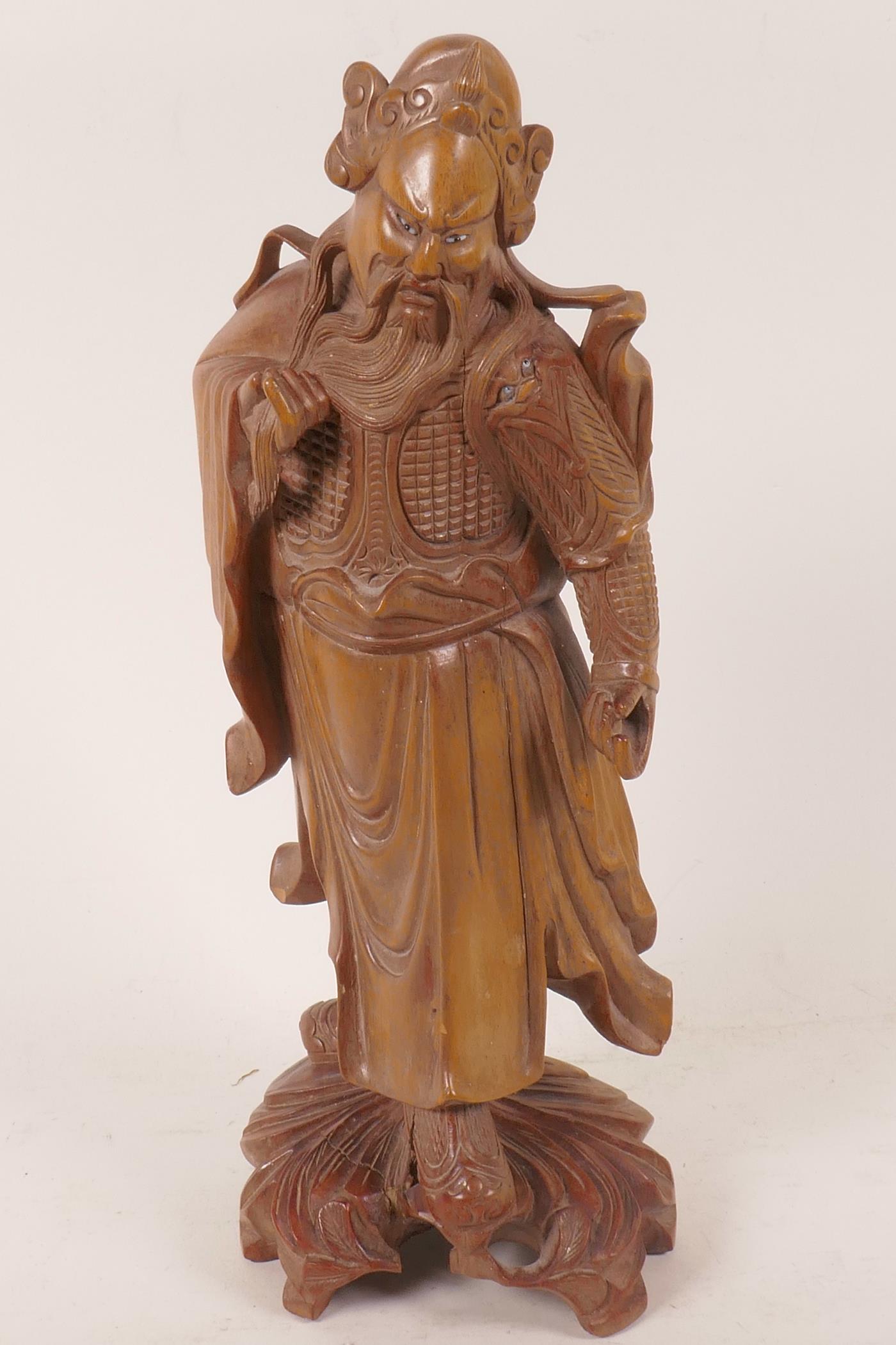 A Chinese carved hardwood figure of a sage with bone and glass eyes, 12" high