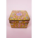 A C19th Cantonese square enamel box with cover, decorated with flowers, motifs and scrolls on a