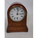 An oak cased dome top mantel clock by Bobby & Jennings of Ipswich, with silvered dial and Roman