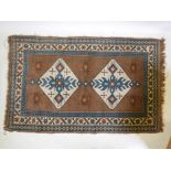 A Middle Eastern wool village rug with geometric patterns on a brown field with a blue border, 74" x