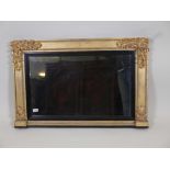 A William IV watergilt overmantel mirror, with carved decoration and reeded ebony slip, 39" x 26"