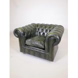 A green leather tub chair, matches previous lot