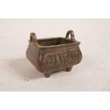 A Chinese bronze censer with two handles and cursive inscriptions to side, impressed character