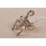 A silver ring set with a silver articulated scorpion, approximate size 'O'
