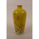 A Chinese polychrome porcelain vase decorated with birds and flowers on a yellow field, seal mark to