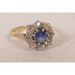 An 18ct gold sapphire and diamond ring, the central sapphire surrounded by eight bright cut