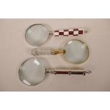 A table top magnifying glass, 4" diameter, together with two others, one chrome handled and one bone