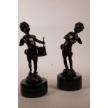 A pair of bronze figures of putti with musical instruments after Moreau, raised on polished stone