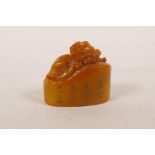 A Chinese amber soapstone seal with carved kylin decoration, 1½" long, 1½" high