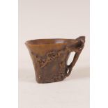 A late C18th/early C19th Chinese rhinoceros horn libation cup, with carved prunus blossom branch