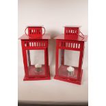 A pair of painted metal and glass garden candle lanterns, 18" high, 9½" square