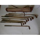 A set of vintage wooden shaft golf clubs, seven irons, putters and wooden head driver, with
