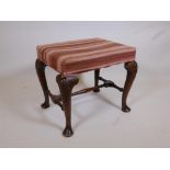 A Georgian walnut footstool on cabriole legs united by an 'H' stretcher, 23" x 18", 19½" high