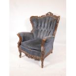 A French carved walnut armchair with wing back, raised on cabriole supports