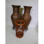 A large pair of woven floor vases in brass frames, and a cane stick stand