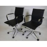 A pair of Eames style black leatherette and chrome office chairs