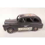 A tin plate model of a London taxi cab, 12½" long