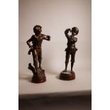 A coppered metal figure of a young harvester and figure, both mounted on wood bases, 15" high