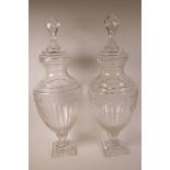 A pair of large glass pedestal urns and covers of baluster form, on a square pedestal base, 28" high
