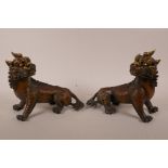 A pair of Chinese filled bronze kylin with gilt highlights, 9" long