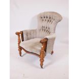 A C19th walnut show frame armchair with scrolled arms and serpentine front, raised on turned