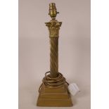 A heavy brass table lamp with spiral twist column and acanthus leaf capital on a stepped and