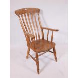 A C19th beechwood Windsor armchair with elm seat and scrolled arms