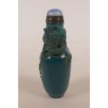 A Chinese blue glass snuff bottle with carved decoration of a dragon chasing the flaming pearl, 4"