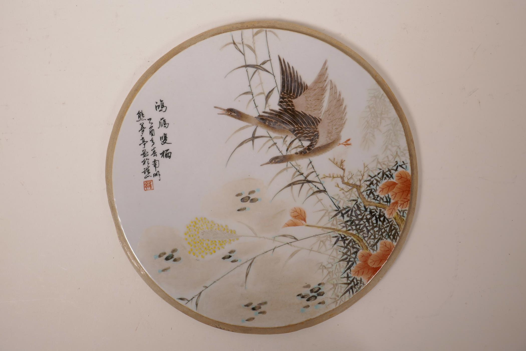 A Chinese polychrome porcelain plaque decorated with waterfowl, 11" diameter