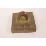 A Chinese bronze seal of square form with loop handle, engraved with calligraphy, 2" square
