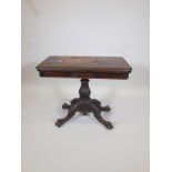 A Victorian rosewood fold over card table on a shaped column, carved legs and paw feet, 36" x 18",