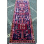 A Middle Eastern hand woven wool runner with stylised bird designs on a deep blue field and