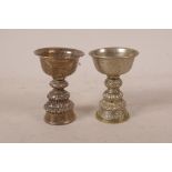 A near pair of Tibetan low grade silver butter lamps, 3" high