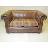 A brown leather two seater sofa with Chesterfield style scroll arms and back