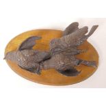 A wall plaque cast as three bronze birds, 10" long