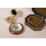 A brass sundial compass in a fitted hardwood box, 4½" x 3½", together with a brass military style