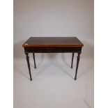 A C19th mahogany fold over top card table, with crossbanded inlaid top, raised on turned, tapered