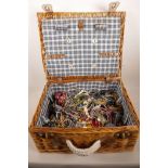 A wicker picnic basket containing a large quantity of costume jewellery
